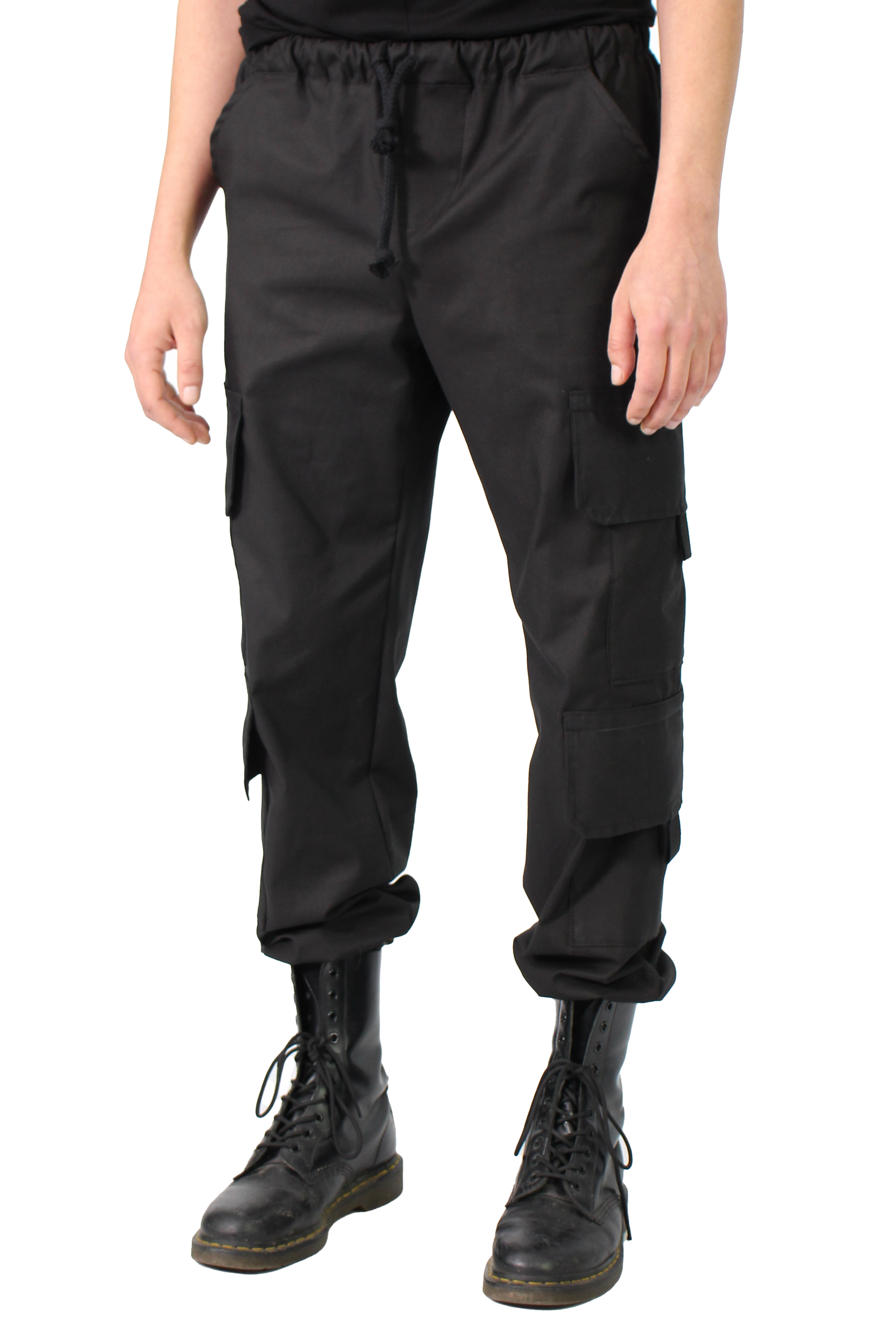Person wearing black cargo pants and black boots on a white background