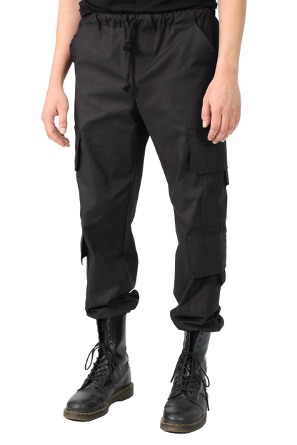 Person wearing black cargo pants and black boots on a white background